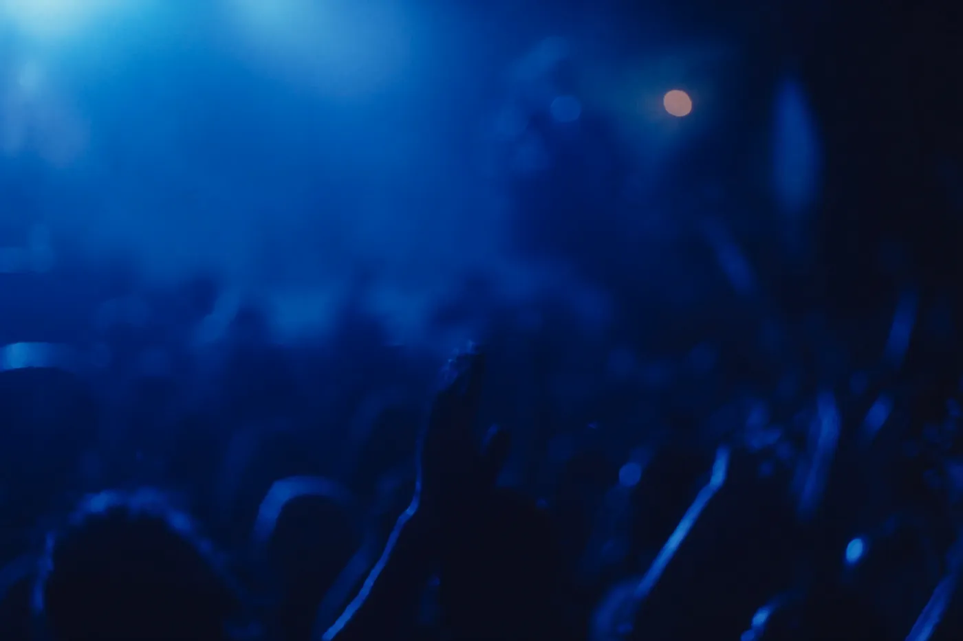 A festival crowd under electric blue stage lights